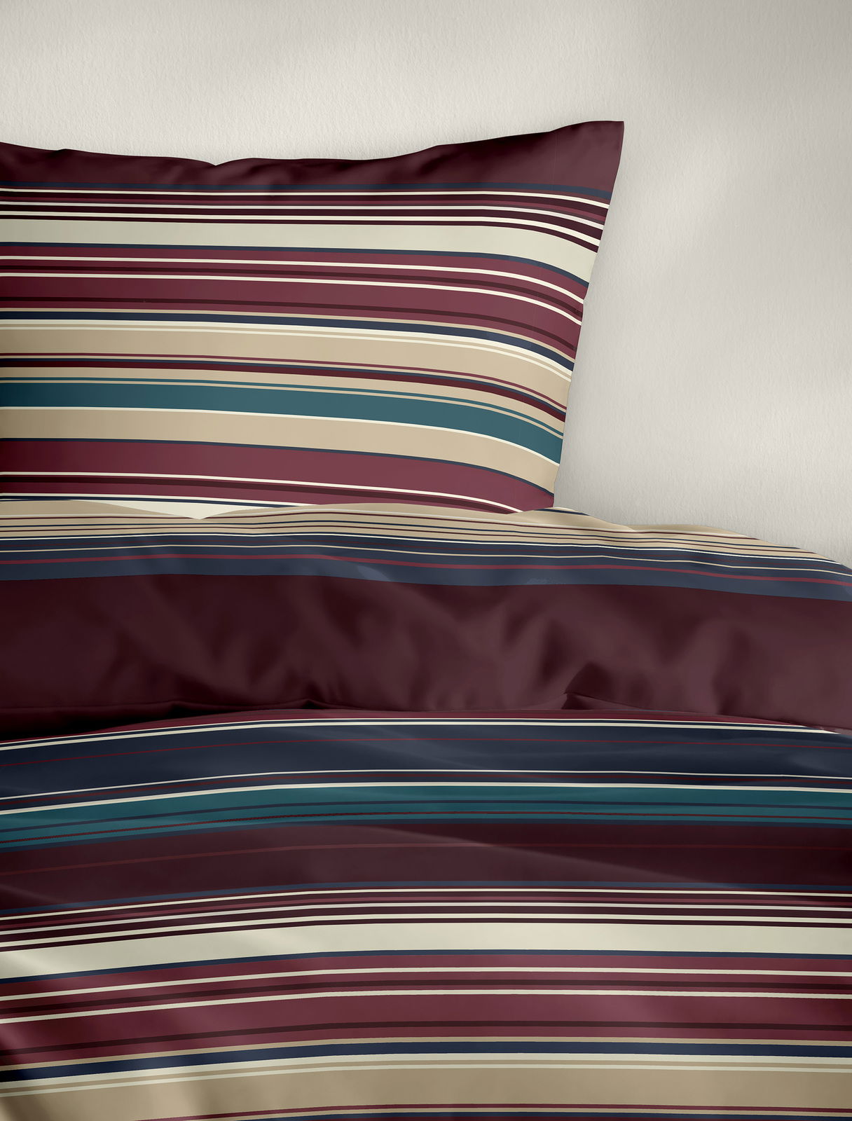Bettwäsche mit Streifenmuster in Rot-, Blau- und Beigetönen, perspektivisch von oben fotografiert