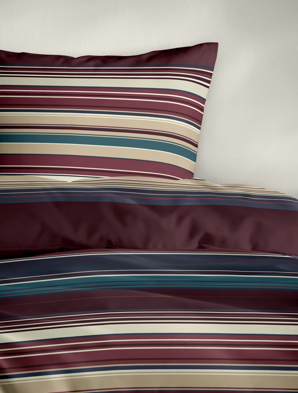 Bettwäsche mit Streifenmuster in Rot-, Blau- und Beigetönen, perspektivisch von oben fotografiert