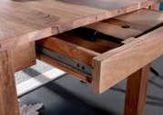 Nahaufnahme eines Esstisches aus Holz mit ausgezogenem Schubfach, seitliche Perspektive