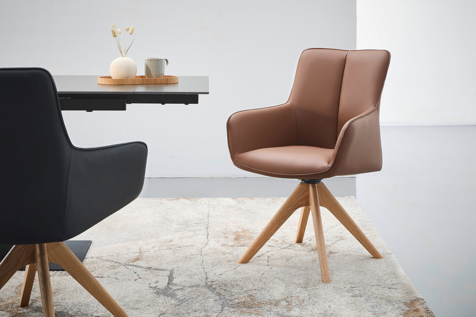 Brauner Armlehnstuhl mit Holzbeinen, seitliche Perspektive, neben einem Tisch mit Dekoration.