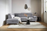 Graue Rundecke (L) in einem modernen Wohnzimmer, von vorne betrachtet, mit einem Beistelltisch und Dekorationen.