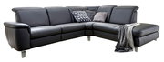 Dunkelgraues L-förmiges Ecksofa mit Recamiere rechts, gepolsterten Armlehnen und Metallfüßen, dekoriert mit Kissen und Decke, in schräger Frontansicht