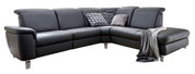 Dunkelgraues L-förmiges Ecksofa mit Recamiere rechts, gepolsterten Armlehnen und Metallfüßen, dekoriert mit Kissen und Decke, in schräger Frontansicht