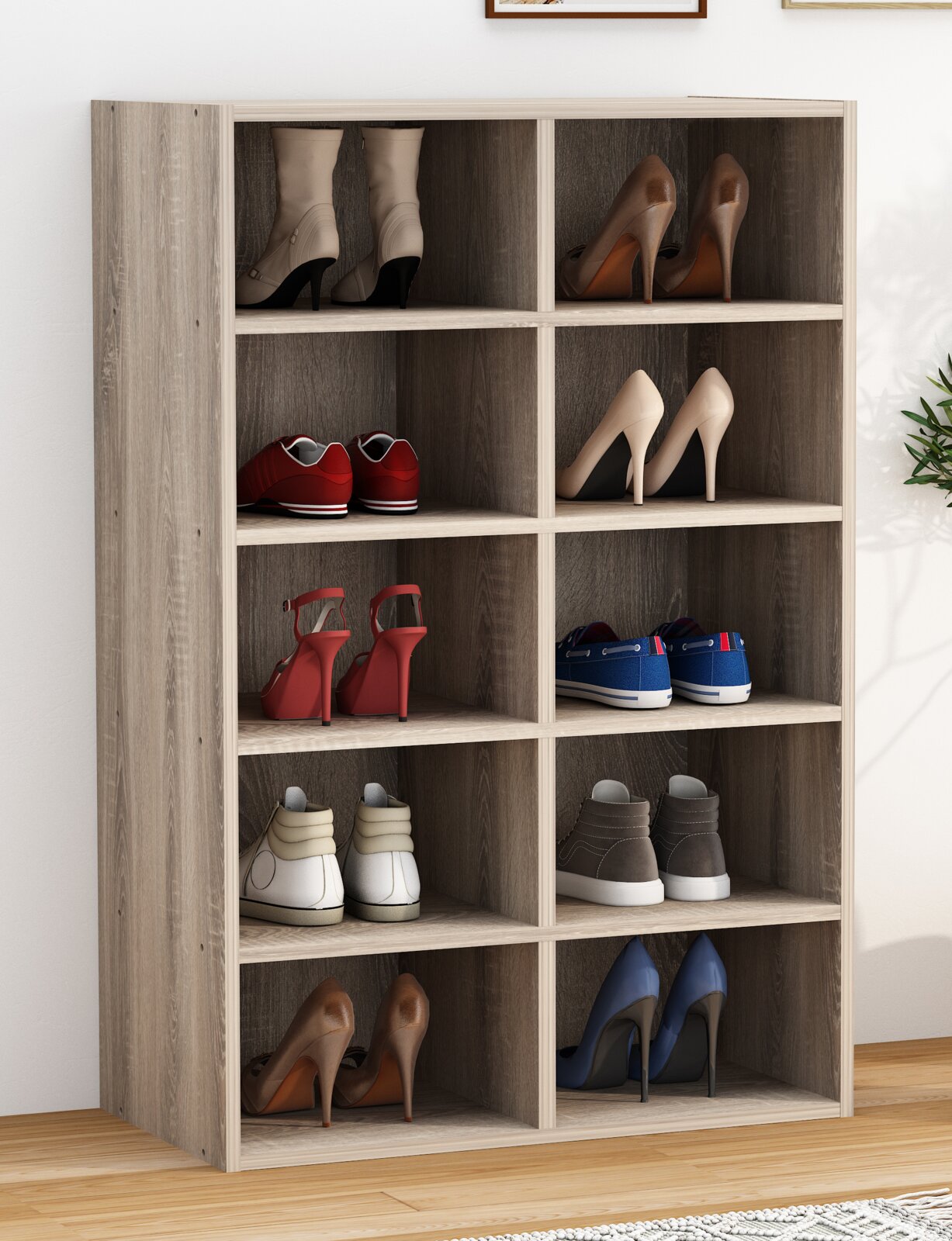 Schuhregal aus Holz in heller Eiche-Optik mit 10 offenen Fächern, gefüllt mit verschiedenen Schuhpaaren; Frontansicht leicht schräg von links.