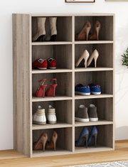 Schuhregal aus Holz in heller Eiche-Optik mit 10 offenen Fächern, gefüllt mit verschiedenen Schuhpaaren; Frontansicht leicht schräg von links.
