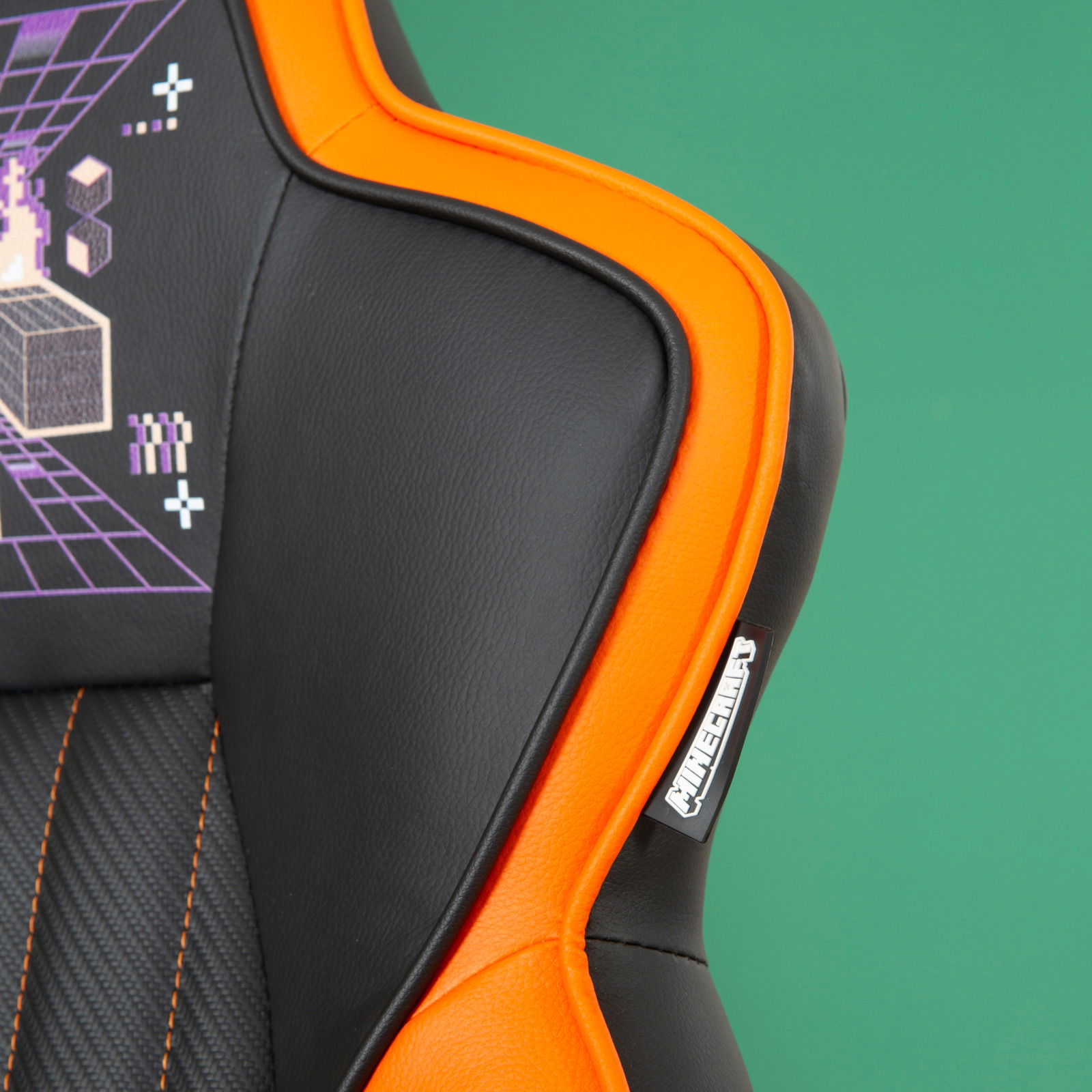 Detailansicht eines Gaming-Stuhls mit schwarzem und orangefarbenem Design, grafischen Mustern und einem Markenlogo.