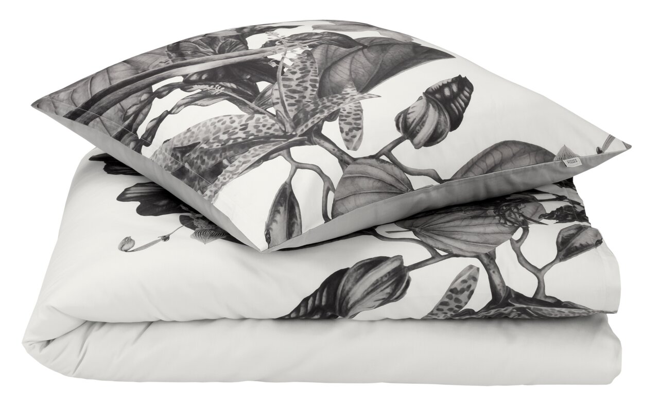 Satin-Bettwäsche-Set AMALIA mit floralem Muster in Schwarz-Weiß, bestehend aus einem Kissenbezug und einem Bettdeckenbezug, aus der Vogelperspektive.