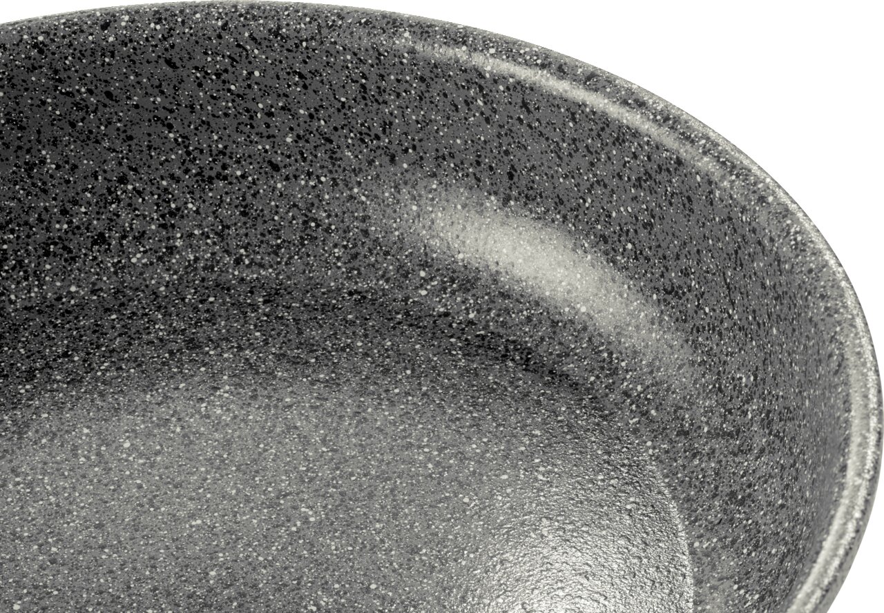 Nahaufnahme einer grauen, gesprenkelten Pfanne mit Antihaftbeschichtung, Blick von oben.