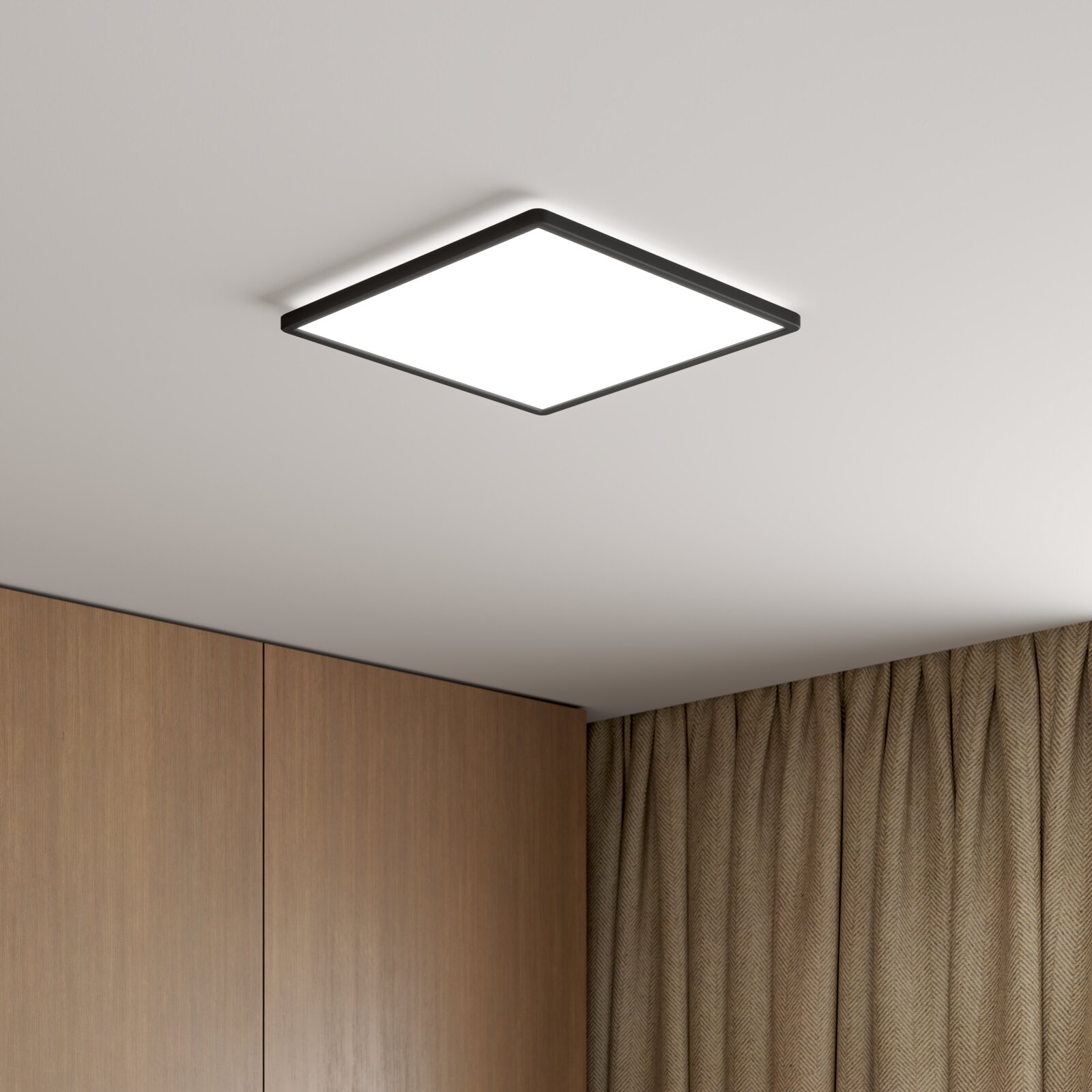 Novel LED-plafondlamp DECKENLEUCHTE Vierkante, platte led-plafondlamp met een zwart frame en een diffuus lichtoppervlak, in beeld op een wit plafond, vanuit een schuine hoek van onderaf gefotografeerd