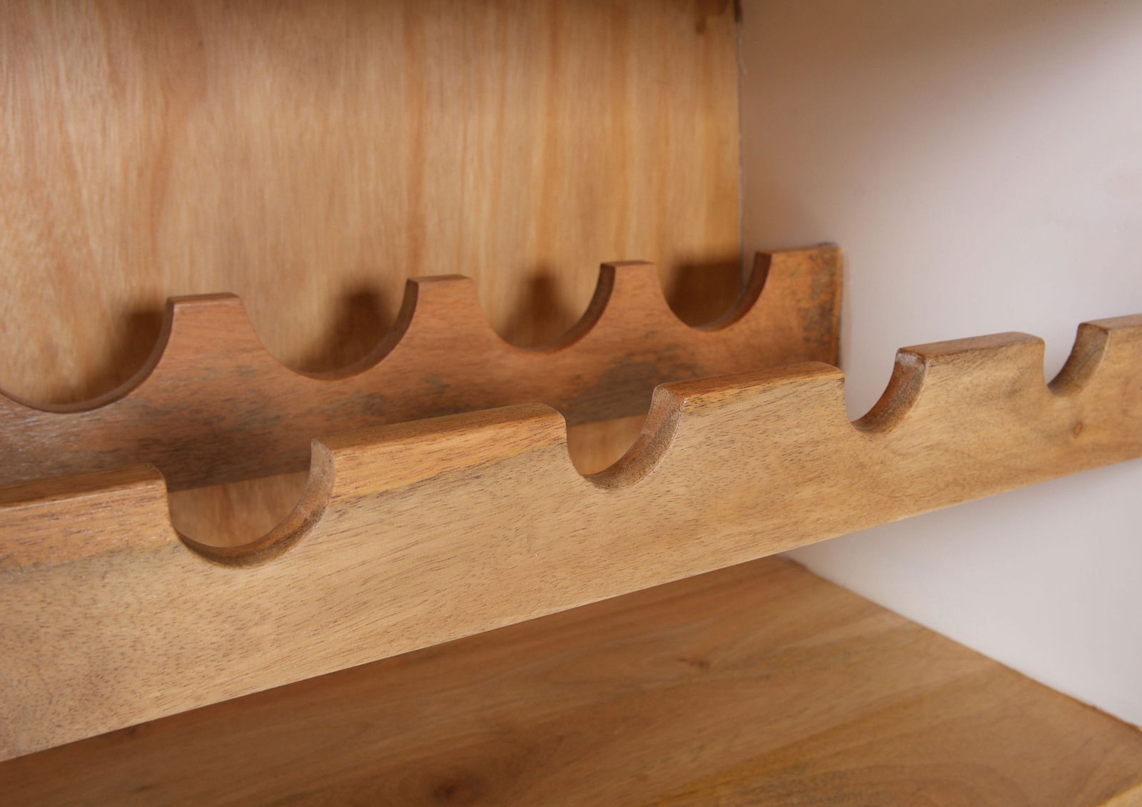 Nahaufnahme eines hölzernen Bar-Regals mit Flaschenhaltern, seitliche Perspektive