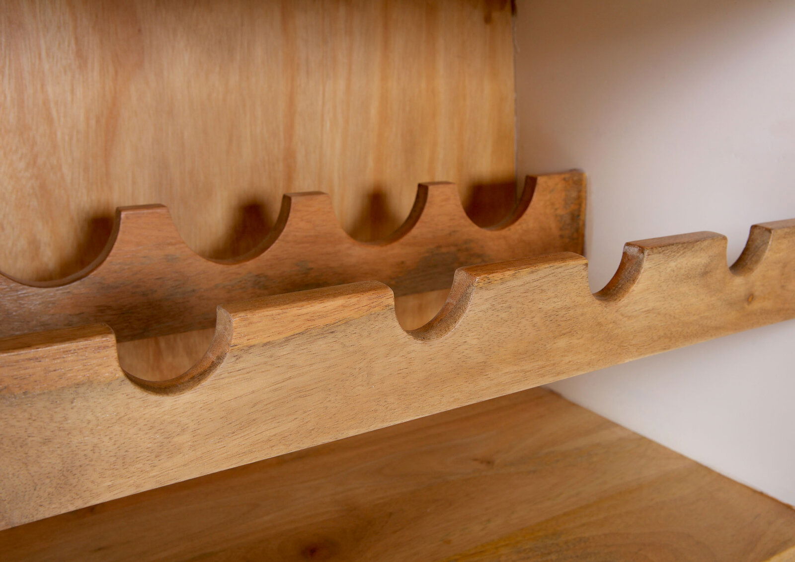 Nahaufnahme eines hölzernen Bar-Regals mit Flaschenhaltern, seitliche Perspektive