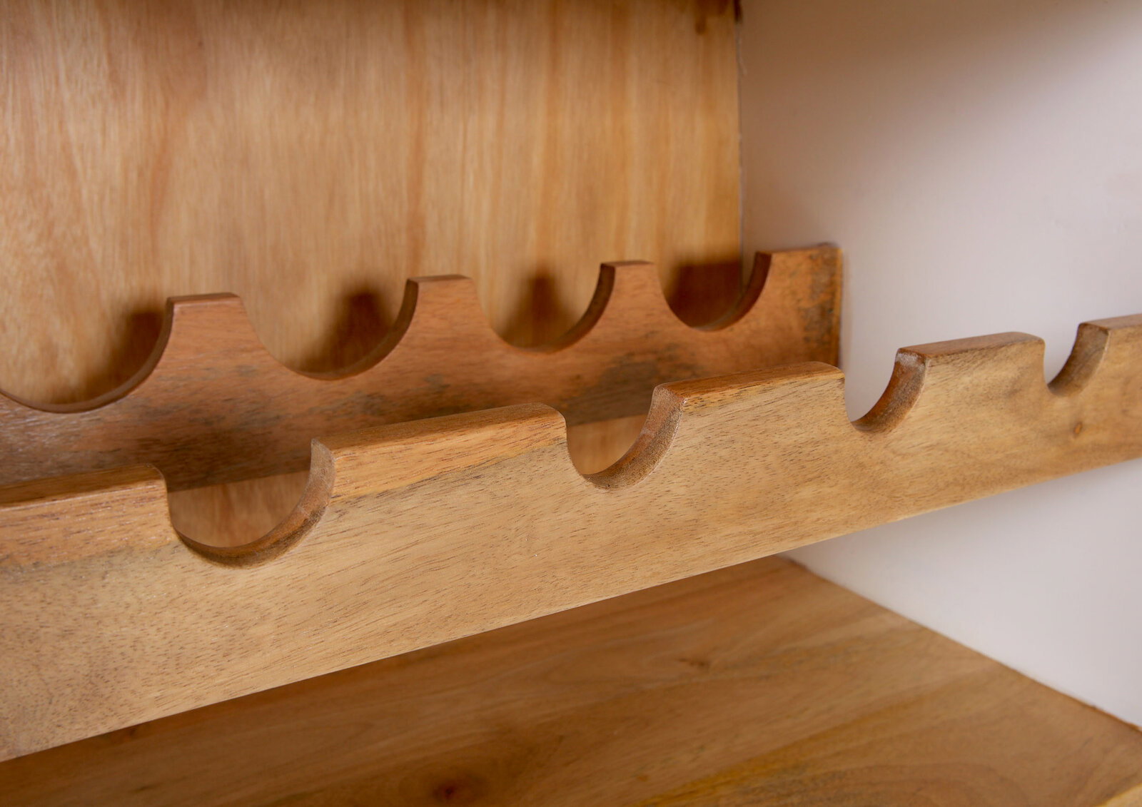 Nahaufnahme eines hölzernen Bar-Regals mit Flaschenhaltern, seitliche Perspektive