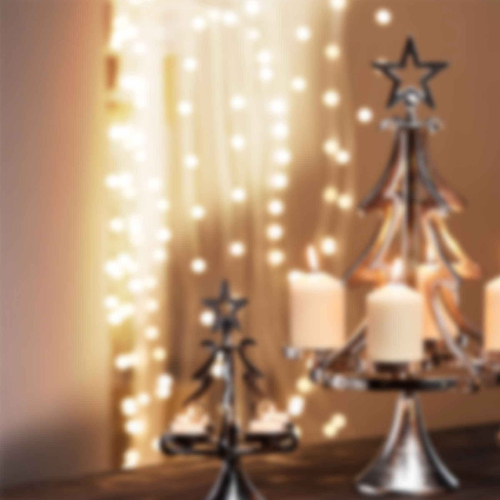 Stimmungsvolle Weihnachtsdeko mit Kerzenhaltern, Sternmotiven und warmen Lichterketten im Hintergrund