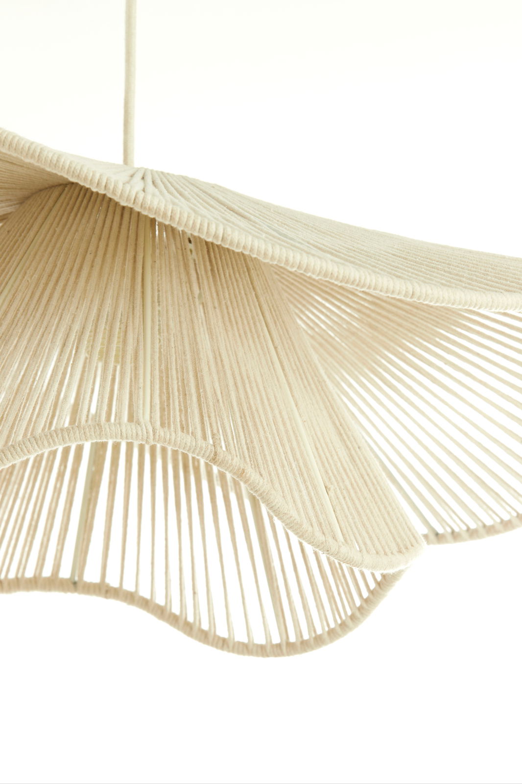 Nahaufnahme einer Hängeleuchte mit einem eleganten, wellenförmigen Design aus beigem Material, von unten betrachtet.