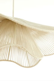 Nahaufnahme einer Hängeleuchte mit einem eleganten, wellenförmigen Design aus beigem Material, von unten betrachtet.