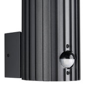 Close-up van een moderne, zwarte buitenwandlamp met bewegingssensor, gezien vanaf de zijkant.
