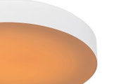 Close-up schuin zijaanzicht van een moderne witte plafondlamp met warme amberkleurige diffuser en zachte lichtgloed