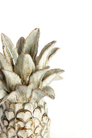 Nahaufnahme eines kunstvollen Keramik-Ornaments in Form einer Ananas, mit detaillierten Blättern und strukturierter Oberfläche, seitliche Perspektive.
