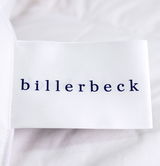 Nahaufnahme eines Etiketts der Billerbeck Daunendecke POLARSTERN, auf einer weißen Oberfläche liegend.