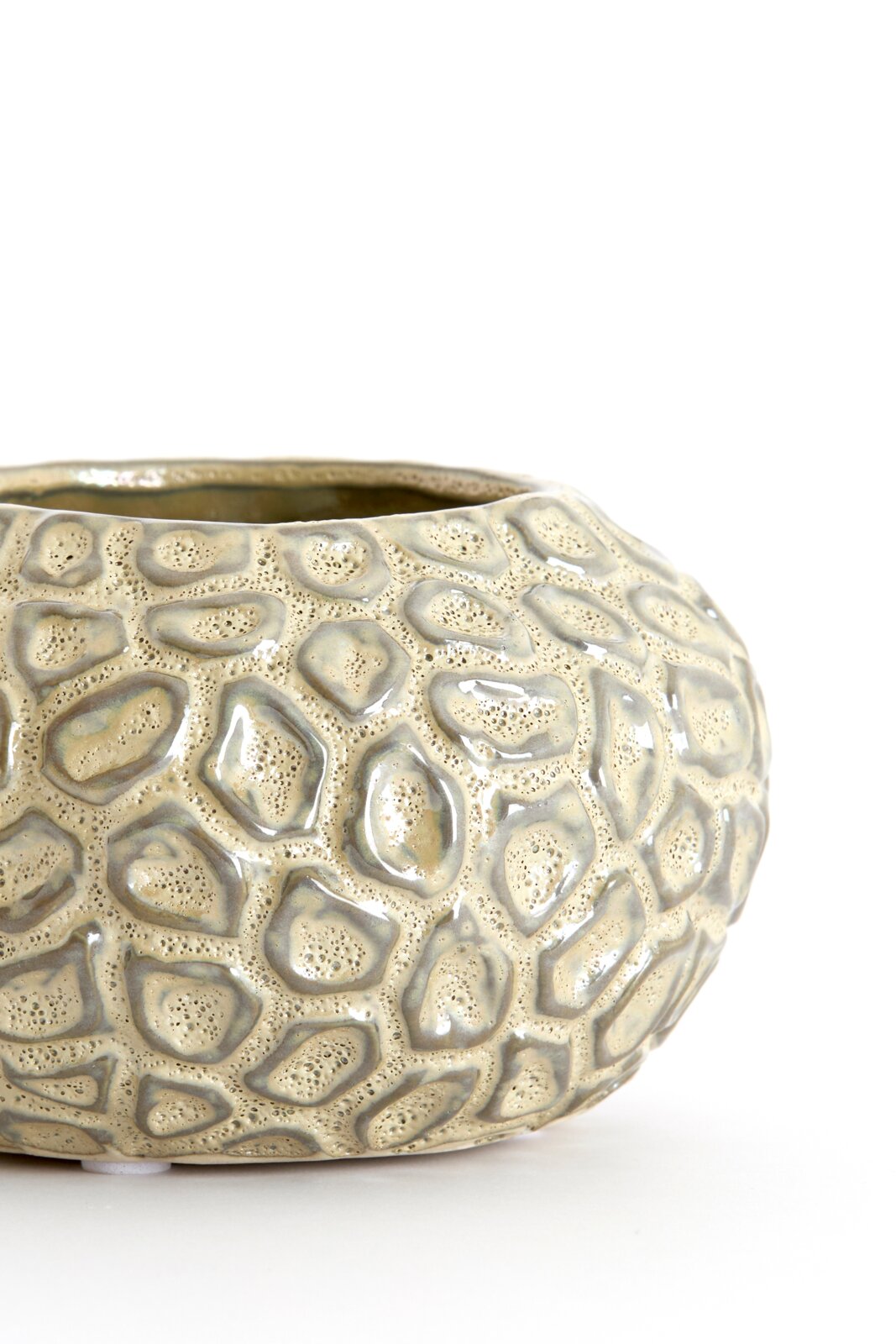 Nahaufnahme eines strukturierten, runden Teelichthalters mit organischem Muster, seitliche Perspektive.
