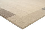 Nahaufnahme eines Wollteppichs in Beige- und Brauntönen, perspektivisch von der Seite aufgenommen.