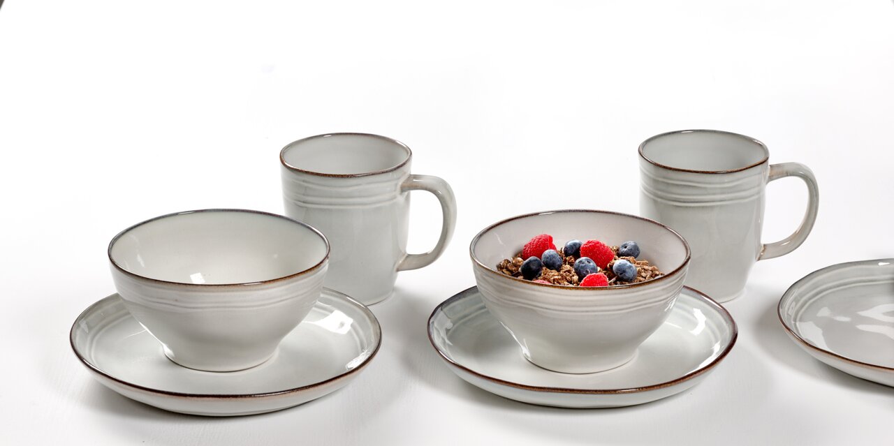 Frontalansicht eines 12-teiligen Frühstückssets mit Tassen, Schalen und Tellern in schlichtem Design.