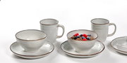 Frontalansicht eines 12-teiligen Frühstückssets mit Tassen, Schalen und Tellern in schlichtem Design.