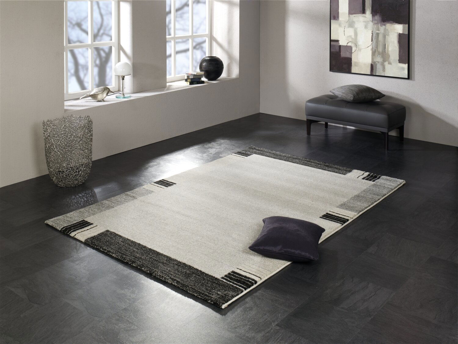 Moderner Teppich in einem eleganten Raum mit großen Fenstern, einem Kunstwerk an der Wand und einem dekorativen Kissen auf dem Teppich. Perspektive von oben.