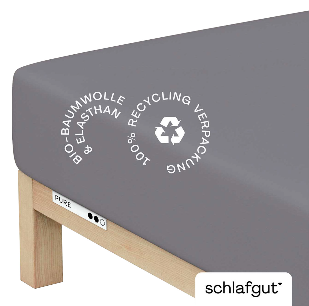 Graues Spannbettlaken aus Bio-Baumwolle und Elasthan, auf einer Matratze von schräg oben fotografiert, mit Hinweis auf 100% recycelte Verpackung.