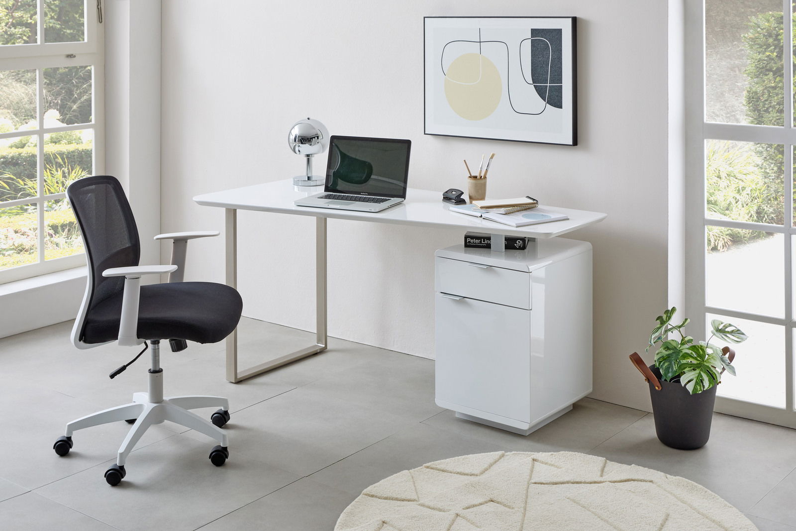 Moderner Schreibtisch mit weißer Tischplatte, Laptop, Lampe und Bürostuhl, seitliche Perspektive