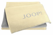 Gelbe Decke mit grauem Schriftzug 'JOOP!' in Nahaufnahme, gefaltet und von oben betrachtet.