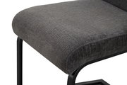 Gepolsterter Hocker mit dunkelgrauem Stoffbezug und schwarzem Metallgestell, Detailansicht aus schräger Seitenperspektive