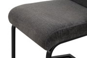 Gepolsterter Hocker mit dunkelgrauem Stoffbezug und schwarzem Metallgestell, Detailansicht aus schräger Seitenperspektive