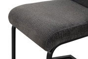 Gepolsterter Hocker mit dunkelgrauem Stoffbezug und schwarzem Metallgestell, Detailansicht aus schräger Seitenperspektive