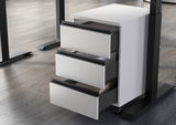 Weißer Rollcontainer mit drei offenen Schubladen, seitliche Perspektive, auf einem Holzboden stehend.