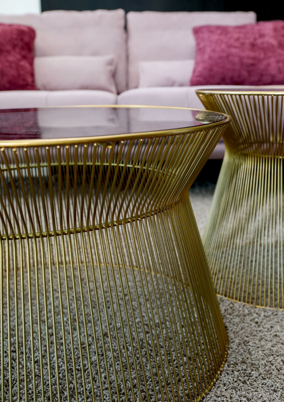 Moderner Couchtisch und Beistelltisch aus goldenen Metallstreben mit Glasplatte, seitliche Perspektive