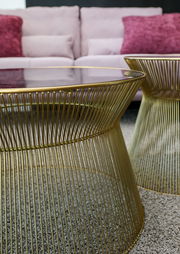 Moderner Couchtisch und Beistelltisch aus goldenen Metallstreben mit Glasplatte, seitliche Perspektive