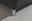 Nahaufnahme eines Boxspringbett-Fußes aus Metall auf einem hellen Teppichboden, perspektivisch von der Seite aufgenommen.