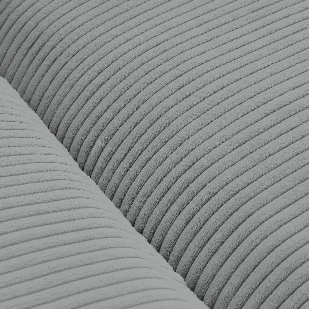 Nahaufnahme eines Big-Sofas mit grauem, geripptem Stoffbezug, von oben betrachtet.