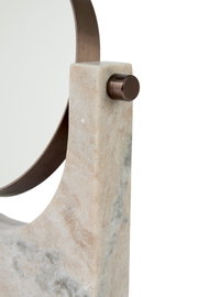 Nahaufnahme aus leicht seitlicher Perspektive auf ein skulpturales Wohnaccessoire aus beigefarbenem Naturstein mit geschwungenem, bronzefarbenem Metallbügel und rundem Befestigungsknopf.