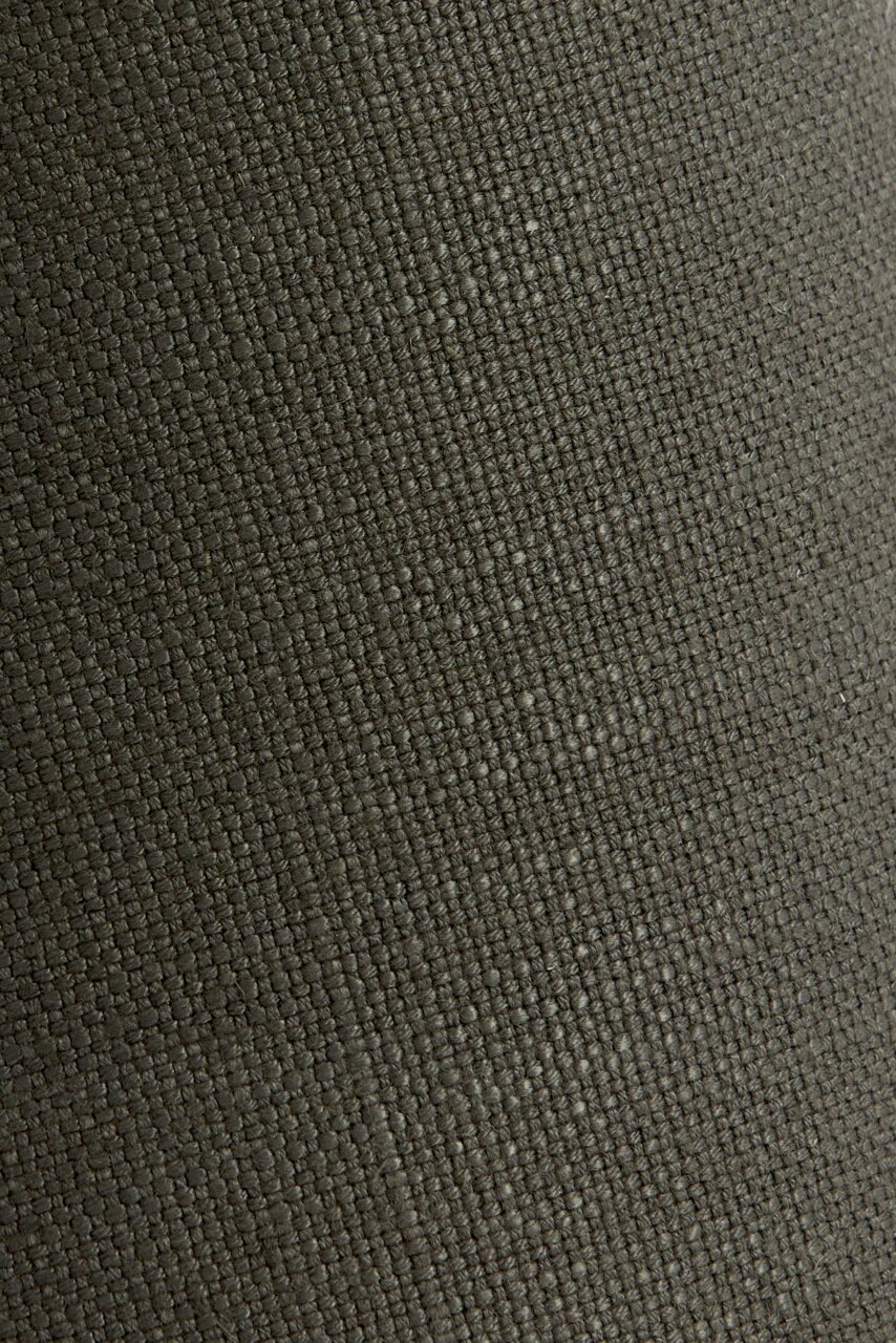 Nahaufnahme eines runden Lampenschirms mit grober, gewebter Textur in dunkler Farbe.