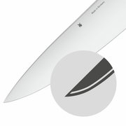 Nahaufnahme eines hochwertigen Küchenmessers aus der Grand Gourmet Serie, Klinge mit WMF-Logo und 'Made in Germany' Gravur, seitliche Perspektive.