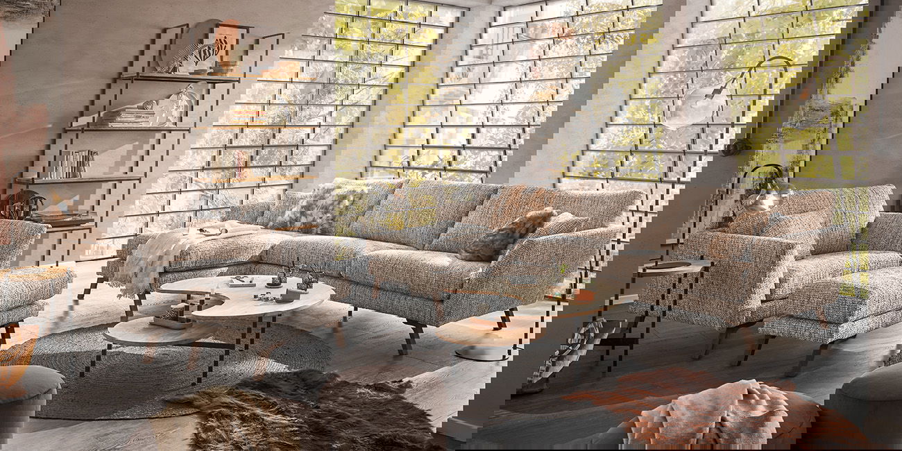 Ein Wohnzimmer mit einem beigen Sofa und einem passenden Sessel.