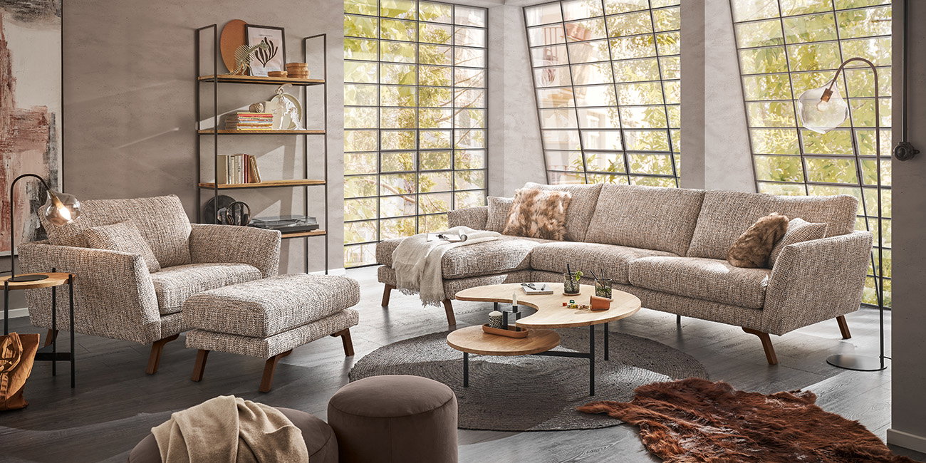 Ein Wohnzimmer mit einem beigen Sofa und einem passenden Sessel.