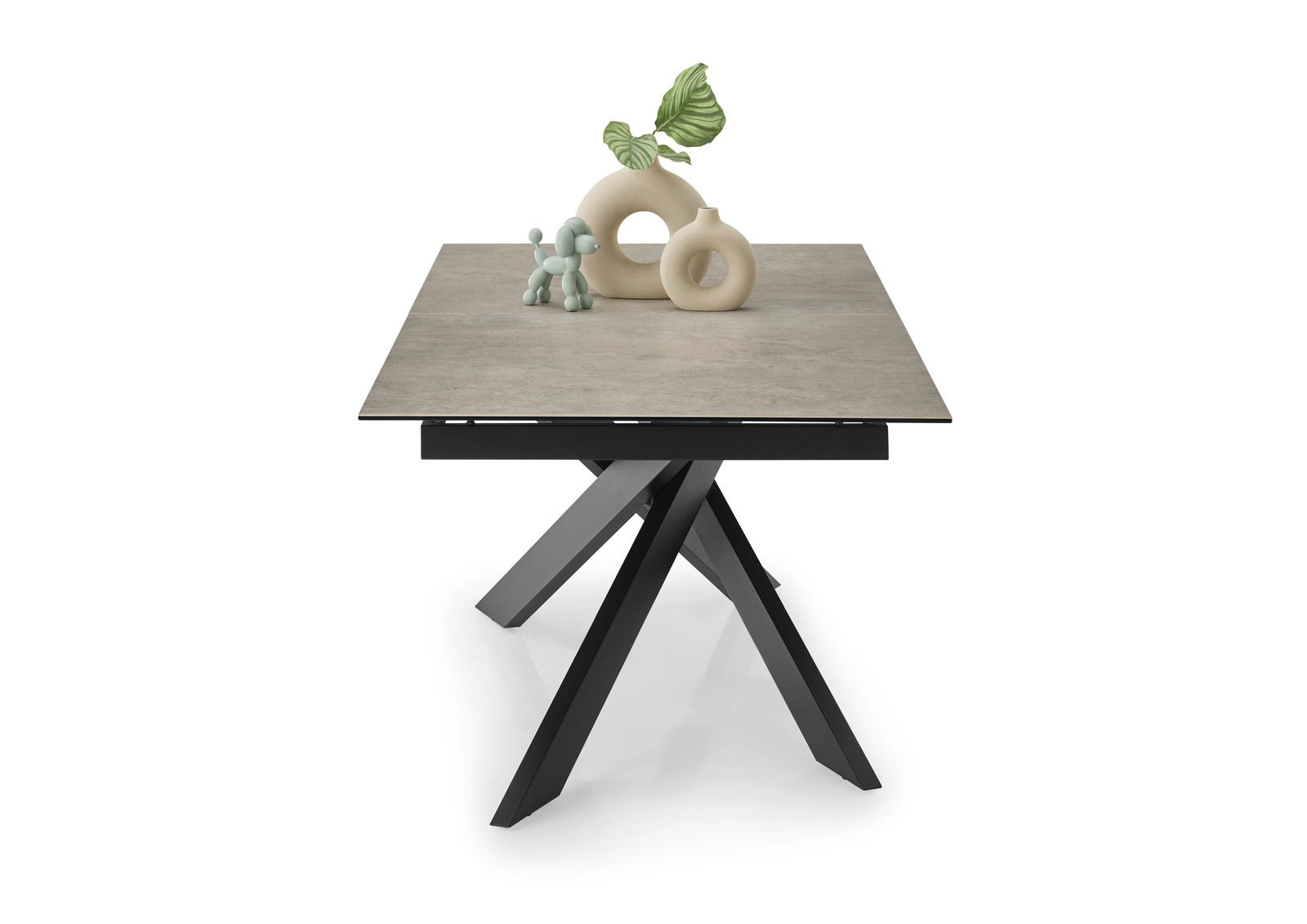 Moderner Esstisch mit quadratischer Steinplatte und schwarzem, gekreuztem Metallgestell, frontal fotografiert.