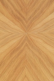 Nahaufnahme der Tischplatte eines Esstisches mit einem geometrischen Holzfurniermuster in warmen Holztönen, von oben betrachtet.