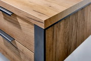 Close-up van een houten bureau met metalen accenten, vanuit de hoek gefotografeerd.