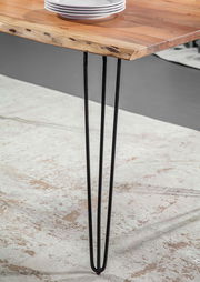 Nahaufnahme eines Esstisches mit einer Tischplatte aus Holz und schwarzen Metallbeinen, seitliche Perspektive.