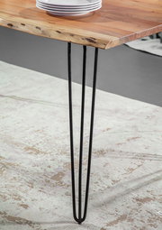 Nahaufnahme eines Esstisches mit einer Tischplatte aus Holz und schwarzen Metallbeinen, seitliche Perspektive.