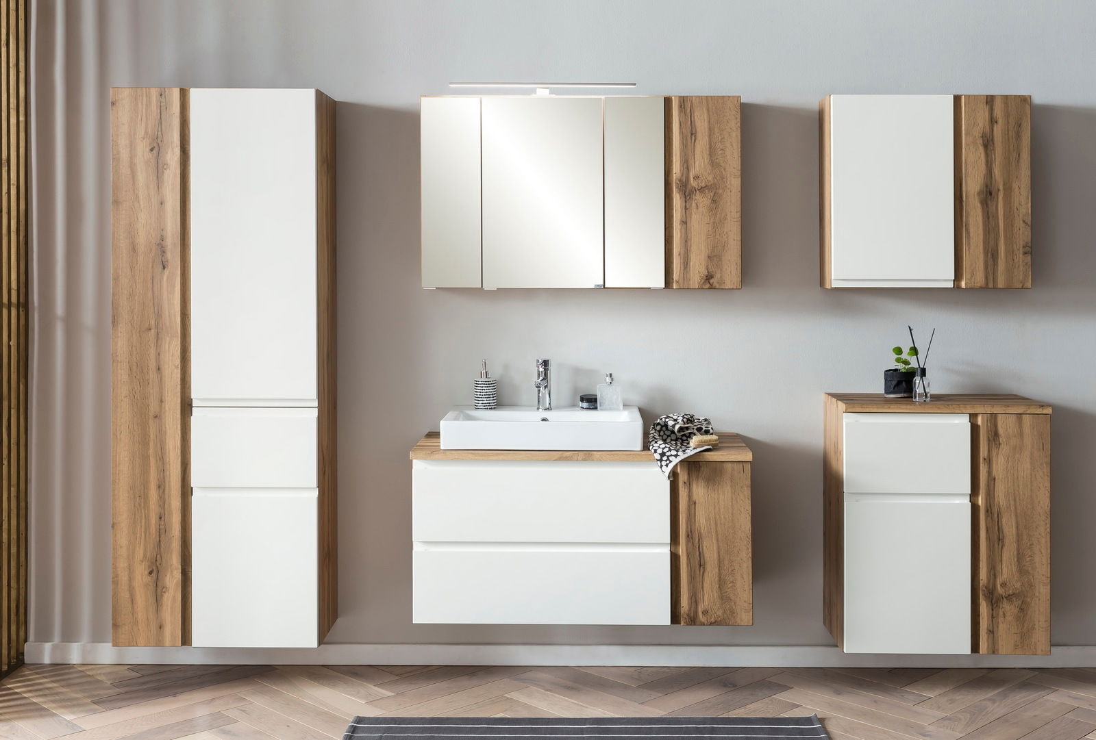 Moderner Hängeschrank 65 cm in Holzoptik mit weißer Front, frontal abgebildet in einem stilvollen Badezimmer-Set.